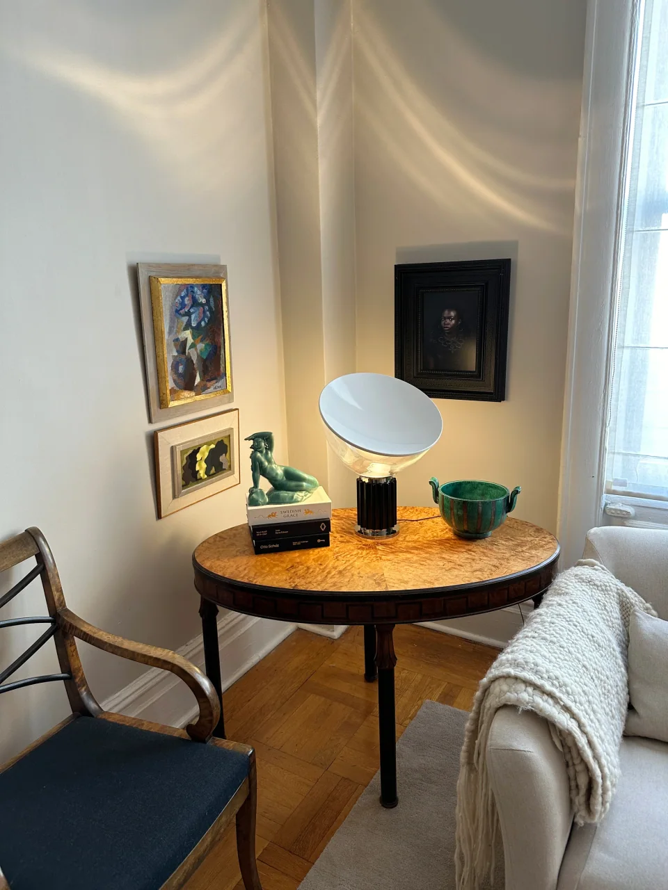 Three framed artworks arranged around a corner above a wood table