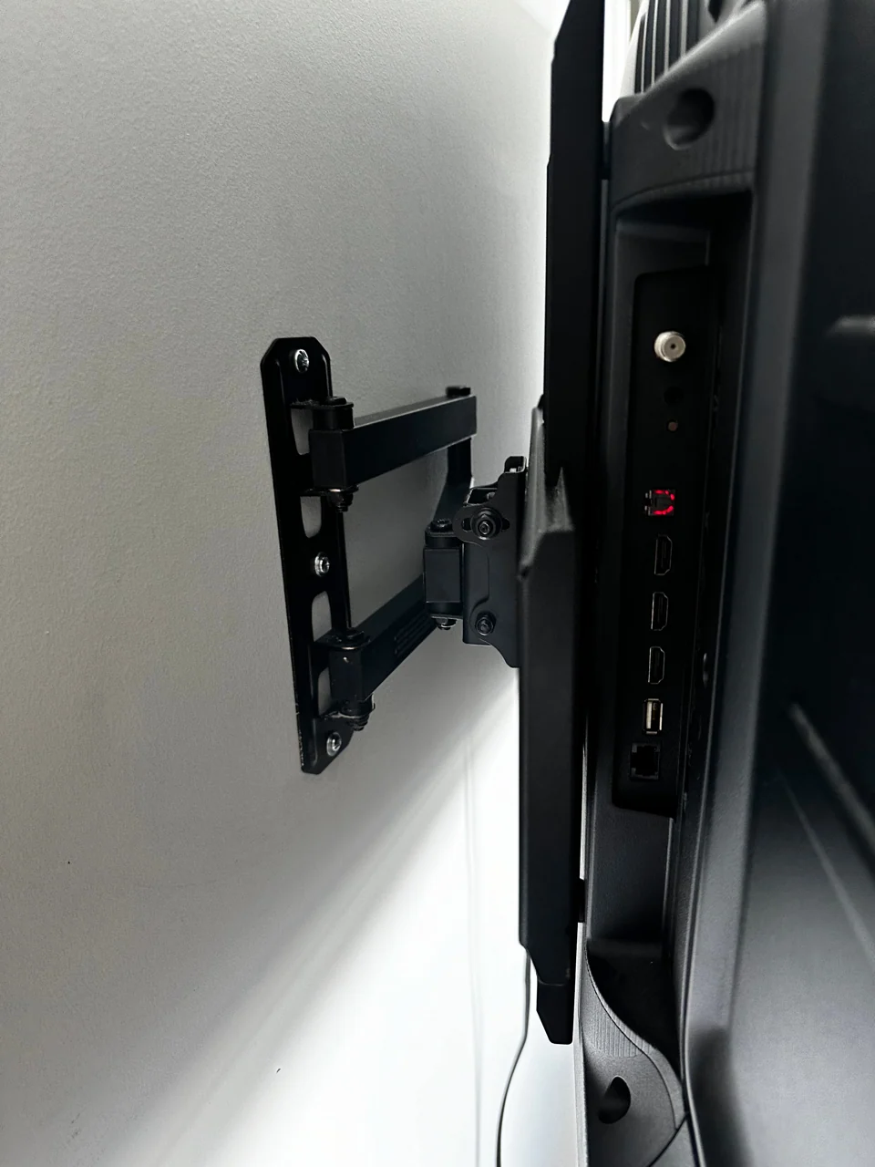 Side view of an extending TV wall bracket and the back of the screen