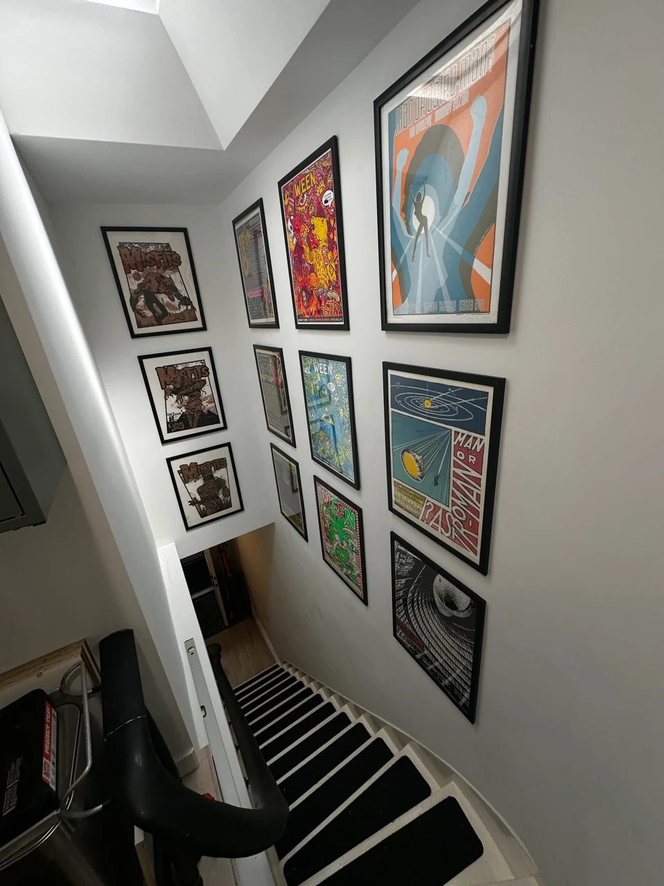 Framed artwork following the walls of a tall stairwell